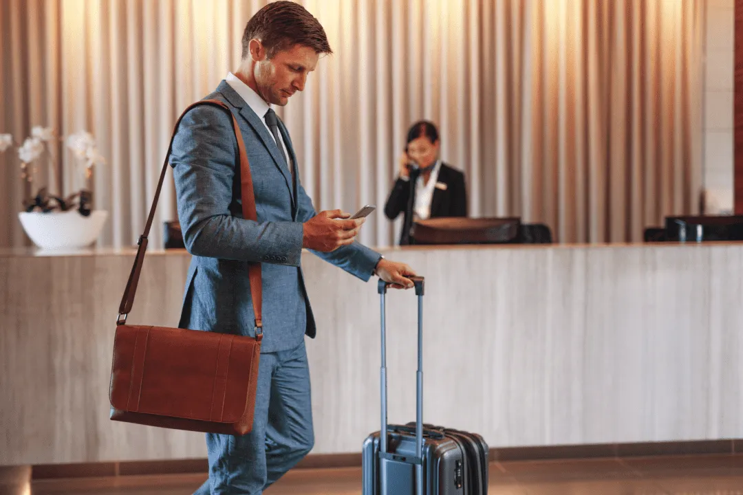 Мужчина с чемоданом на ресепшене