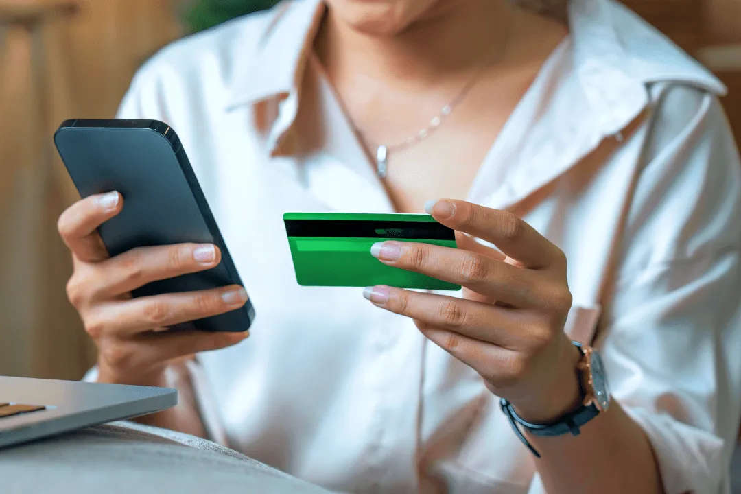 Девушка вводит данные карты в телефон