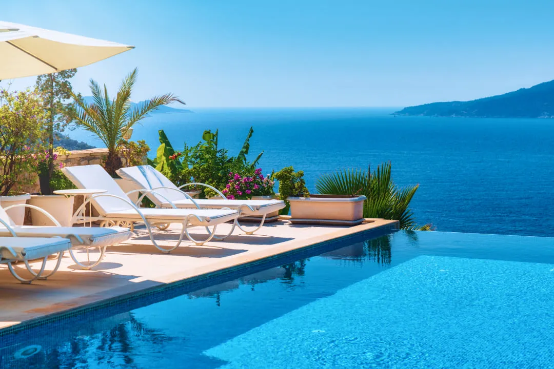 Шезлонги рядом с панорамным бассейном