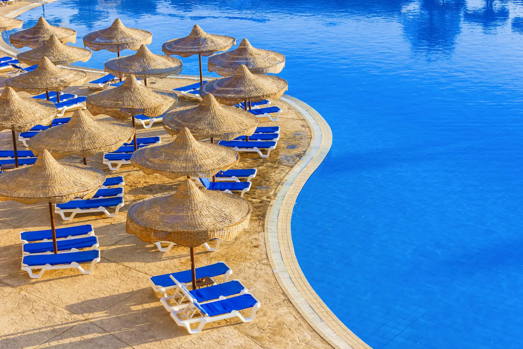 Шезлонги у края бассейна