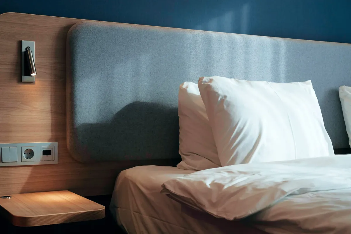 Белые подушки на деревянной кровати