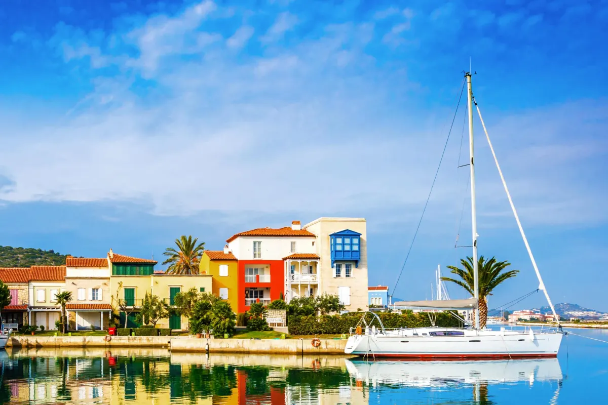 Парусная лодка у ярких домиков