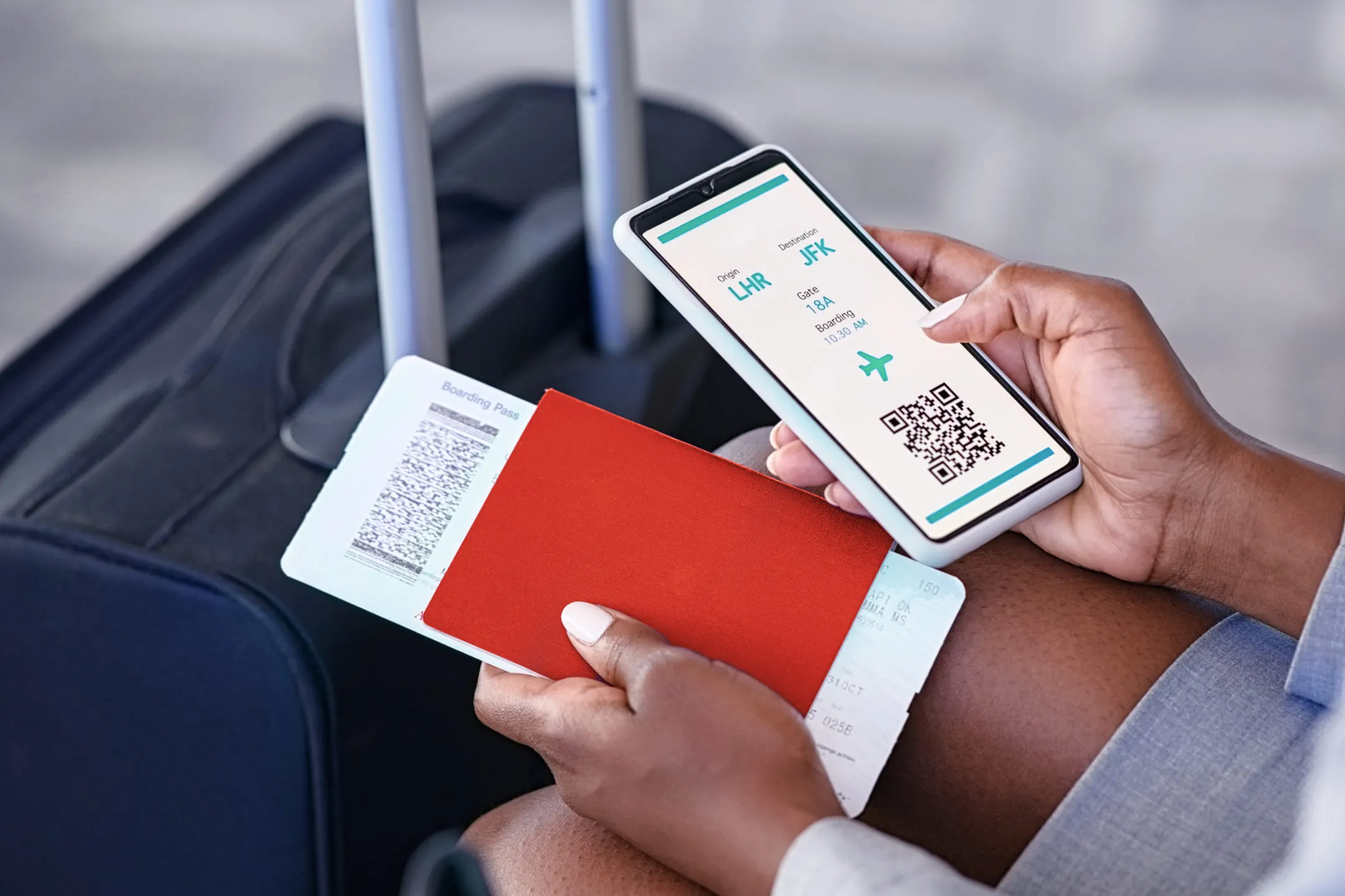 Человек держит в руках телефон и паспорт с билетом