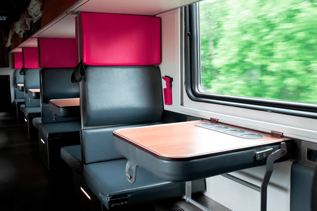 Поезд с черными сидениями мчится вперед