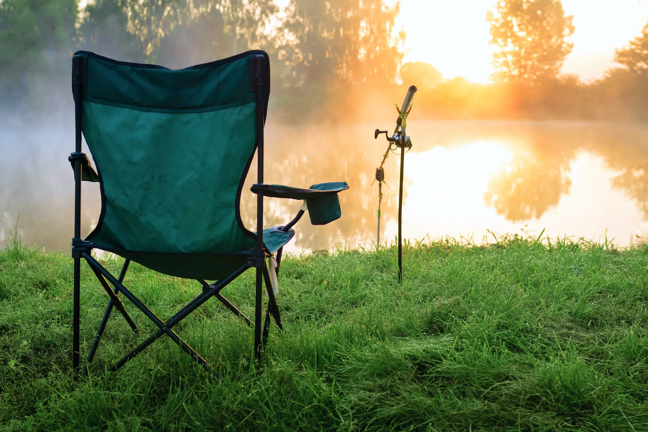 Раскладной стул и удочка около озера