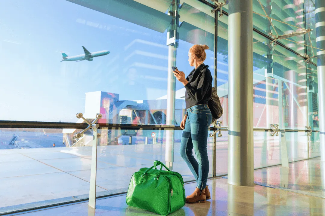 Девушка смотрит на взлетающий самолет