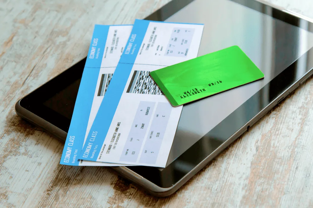 Авиабилеты и банковская карта лежат на планшете
