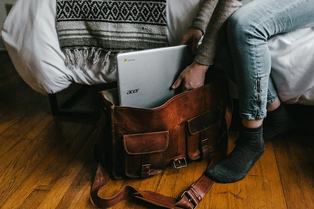 Девушка убирает ноутбук в сумку