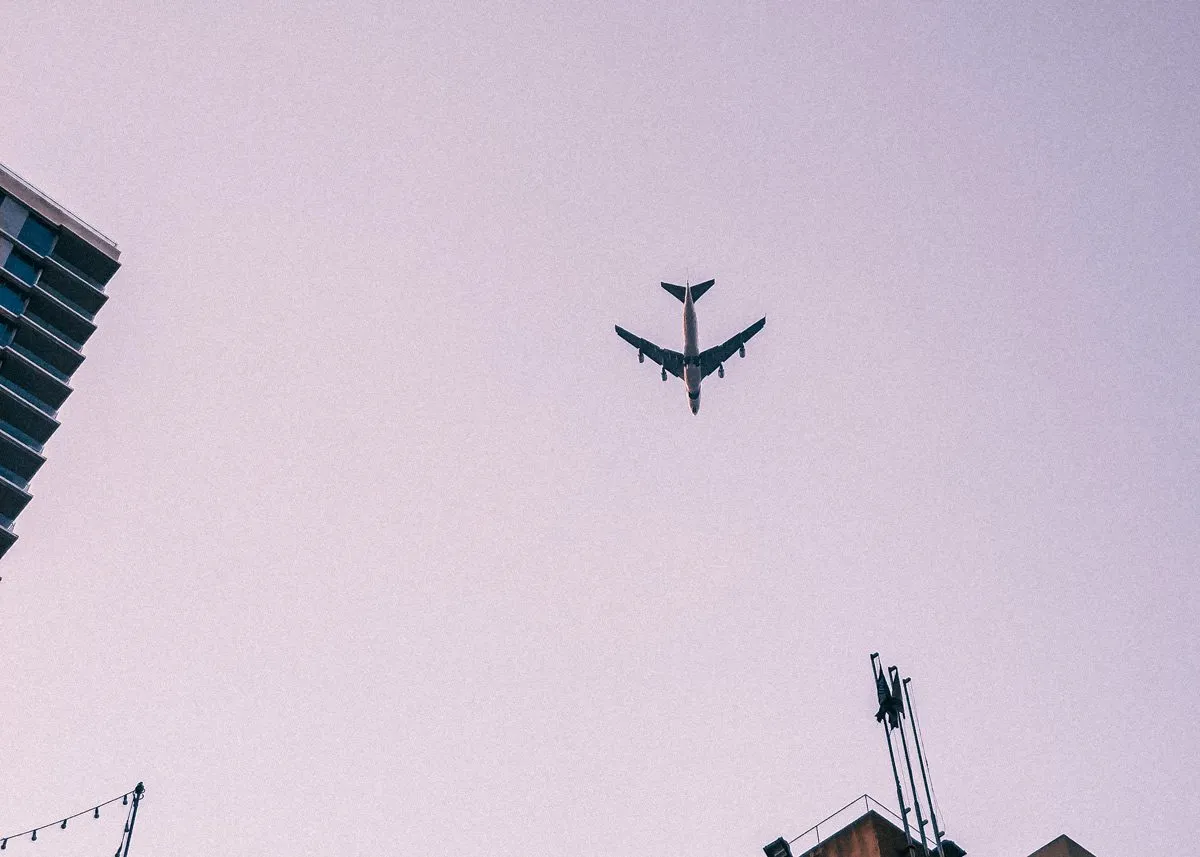 Самолет пролетает меж домов