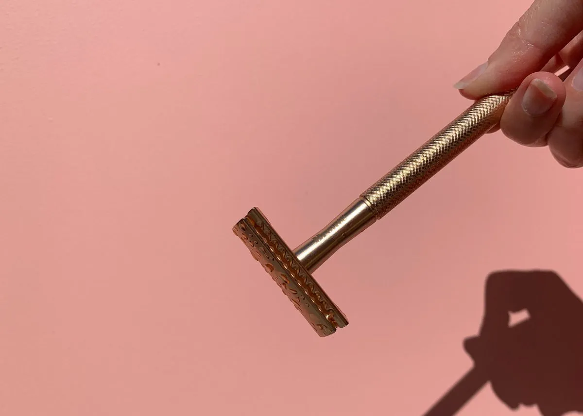 Бритва в руках на розовом фоне