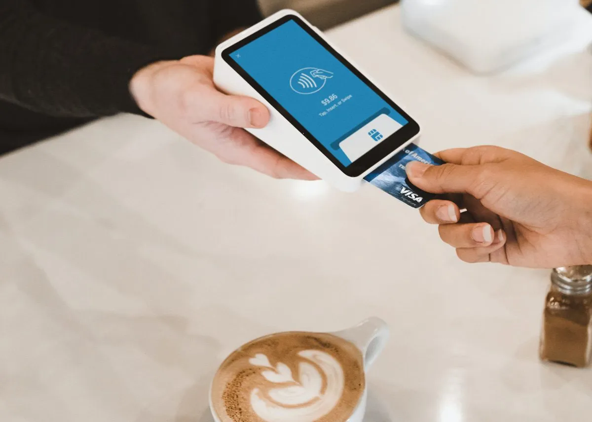 Человек оплачивает свой кофе банковской картой
