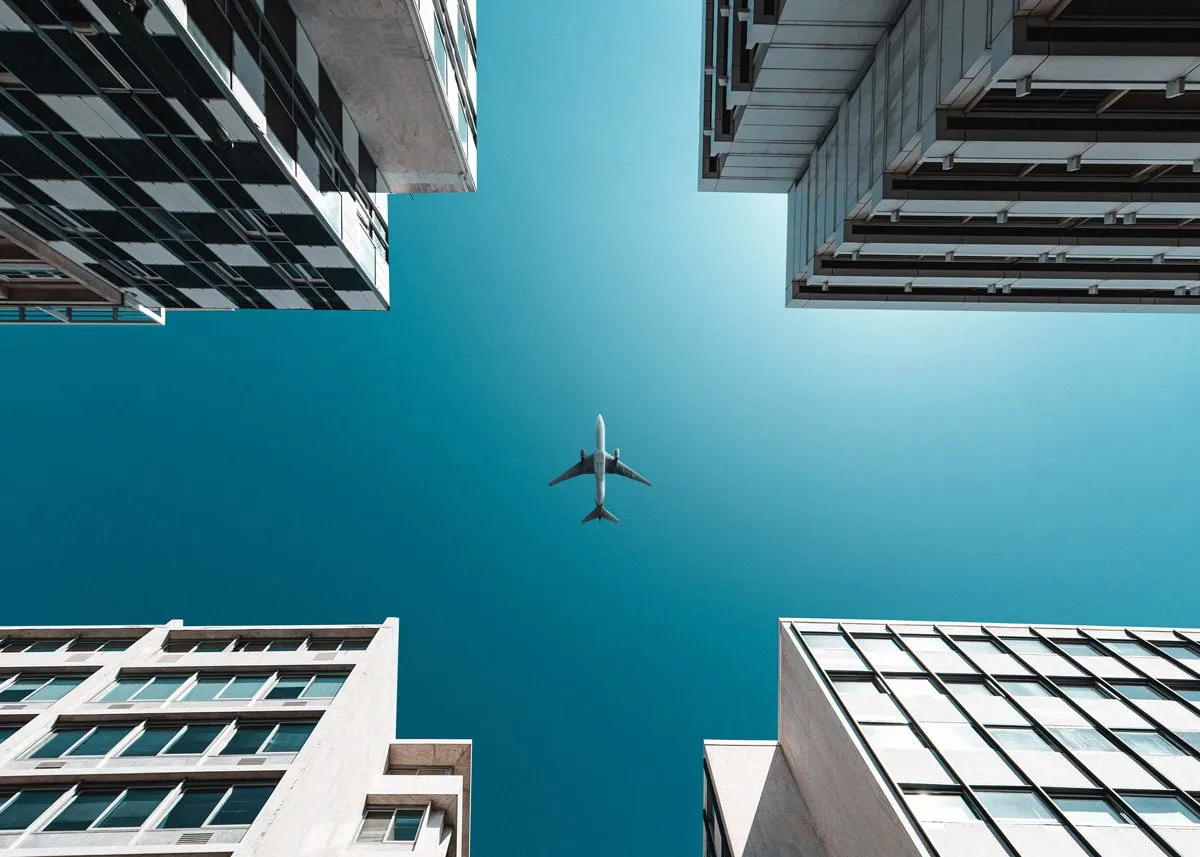 Самолёт пролетает над небоскребами