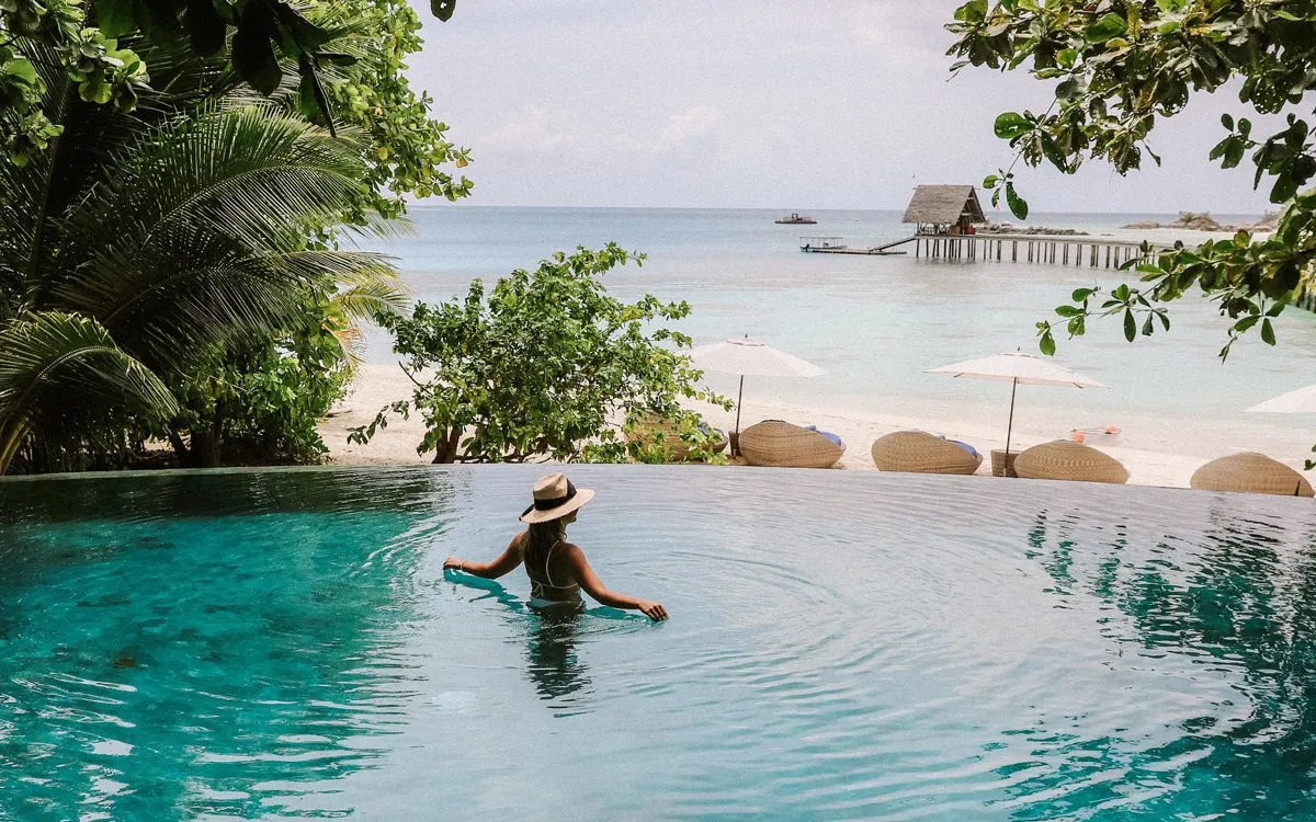 Девушка в бассейне с видом на океан