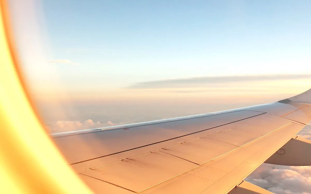 Крыло самолёта в лучах солнца на рассвете